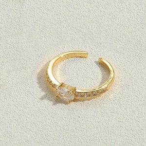 Macro shot of gold open ring featuring oval zircon center stone and side accents