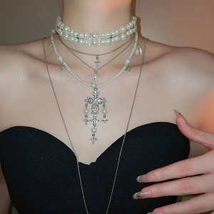 Close-up of elegant double-layer necklace with pearl beads and sparkling crystal cross