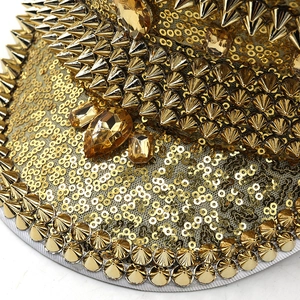 Close-up of golden sequins, metal spikes and amber gemstones on a women's party hat