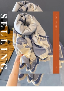 Detail of light blue floral jacquard scarf showing thick texture and tassel fringe edges