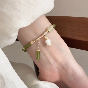 Detail of bamboo joint beads and lily of the valley charm on a Chinese style bracelet