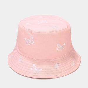 Close-up of delicate white butterfly embroidery on a soft pink cotton bucket hat