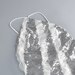 Detail of silver sequins and mesh fabric on elegant halter dress with white straps