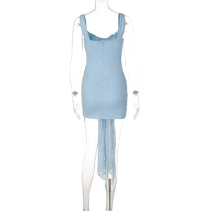 Dettaglio dell'abito corto in pizzo azzurro con orlo drappeggiato sul retro e scollo a V