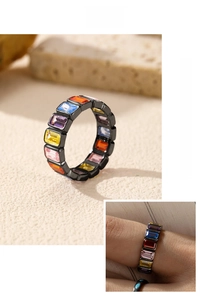 Detailed macro view of rainbow baguette cut stones set in a black plated silver band