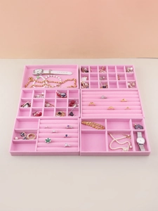 Overhead view of pink velvet jewelry organizer trays with multiple storage compartments