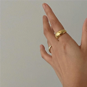 Set of two minimalist polished gold 925 sterling silver rings shown on a finger