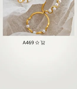 Detail of a wavy gold ring with white pearls on soft white chiffon fabric surface