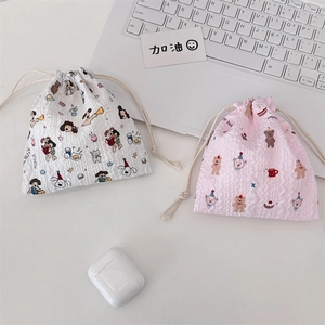 Flat lay of cute cartoon drawstring pouches in cream and pink textured seersucker fabric