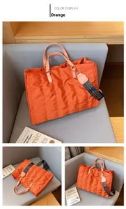 Detail view of orange quilted nylon tote bag with patterned wide detachable shoulder strap