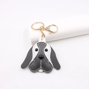 Detail of grey and white leather beagle keychain with gold lobster clasp and fine stitching