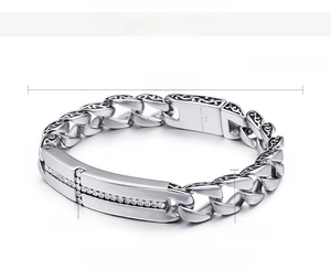 Detail of vintage steel cross bracelet with cubic zirconia and black carved patterns