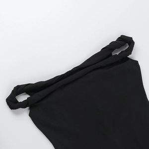 Dettaglio della tuta nera con spalle scoperte e design a nodo ritorto sullo scollo elegante
