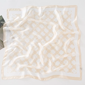 Détail d'un foulard carré en soie avec des motifs à pois floraux élégants à plat