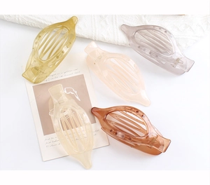 Collection of large oval claw clips in five matte Morandi colors on white knit background