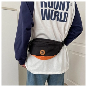 Detail of oxford fabric chest bag with black and orange color block and round logo