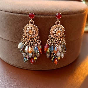 Close-up of vintage gold tassel earrings with colorful crystals and rhinestones