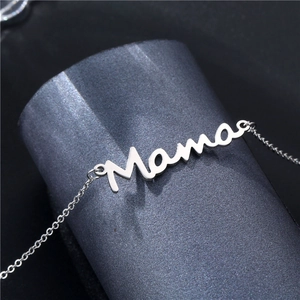 Collier avec pendentif Mama en acier inoxydable poli sur un présentoir élégant