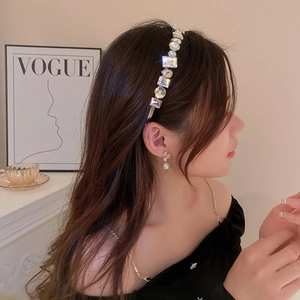 Detail of luxury rhinestone headband featuring square and round crystals on a gold band