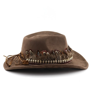 Detail of brown faux suede cowboy hat featuring pheasant feathers and golden skull beads