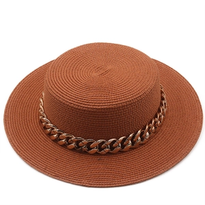 Detail of high-density straw boater hat with stylish gold metal chain decoration
