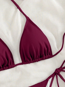 Detail view of burgundy ribbed bikini top with halter tie and triangle pleated fabric texture