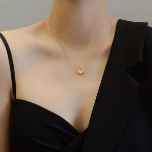 Dettaglio della collana con pendente a cuore dorato e intarsio in conchiglia