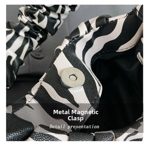 Detail shot of the zebra pattern leather bag with a round silver magnetic buckle closure
