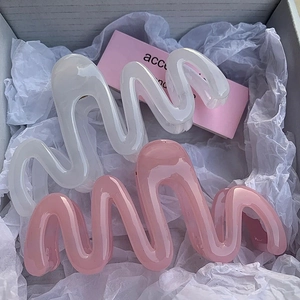 Jelly-colored wavy hair claws in creamy white and pink acrylic for a minimalist summer style