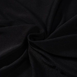 Detailed macro texture of black pleated fabric showing soft ruffles and fine synthetic weave