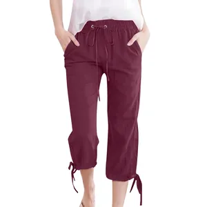 Detail of burgundy linen cropped pants featuring drawstring waist and bow-knot cuffs