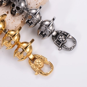 Detail of gothic skull buckle bracelets in gold and antique silver on stone base