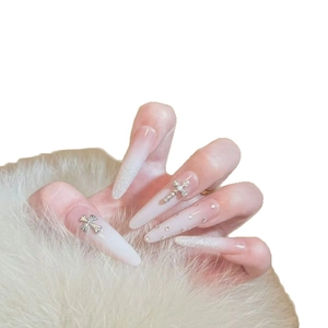 Long almond press-on nails with white gradient finish and silver cross pearl charms