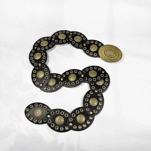Détail d'une ceinture western vintage en cuir noir avec des ornements ovales dorés ciselés