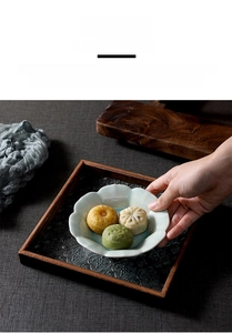 Detailed macro view of wood tray with vintage embossed glass base and ceramic petal bowl