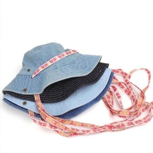 Detailansicht von gewaschenen Denim-Fischerhüten mit bunt gemusterten Bindebändern