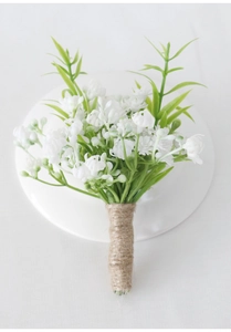 Detailed view of white artificial flowers and green leaves wrapped in rustic hemp rope