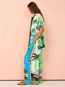 Close-up of tropical print set showing silk-like drape of wide-leg pants and short sleeve shirt
