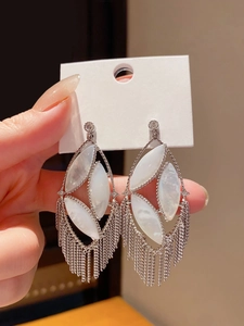 Detailed macro view of vintage hollow oval tassel earrings with silver needle and rhinestones