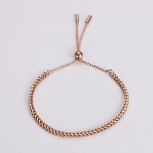 Detail of rose gold braided stainless steel bracelet with adjustable slider clasp