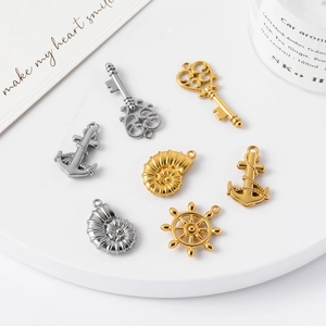 Nautical stainless steel pendants featuring anchors and rudders on a white display