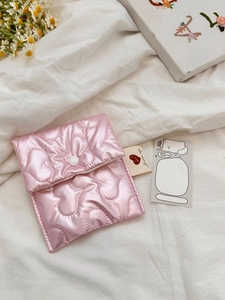 Detailed view of pink heart quilted satin storage bag with a white snap button closure