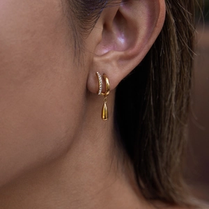 Détail de boucles d'oreilles en C dorées à double couche avec zircon et pendentif goutte