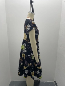 Detail of floral print on tiered cake dress with high waist and short sleeves