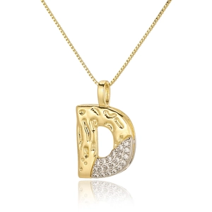 Macro detail of gold and silver D-letter pendant with pavé zircon and hammered texture