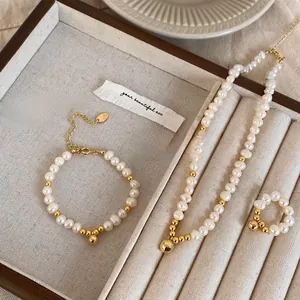 Détail d'un ensemble collier, bracelet et bague en perles d'eau douce et billes dorées