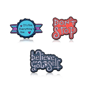 Set of three creative enamel pins with motivational quotes on a white background