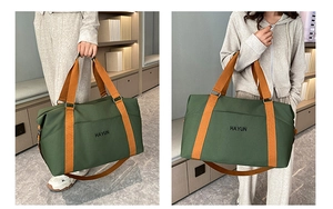 Detail view of large yoga travel bag in green with orange straps and HAYUN logo print