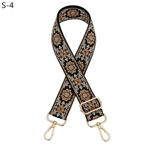 Detail of ethnic style adjustable bag strap with floral embroidery and gold lobster claws