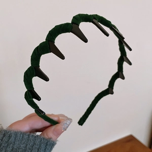 Close-up of deep green velvet headband showing inner plastic teeth for secure hair grip